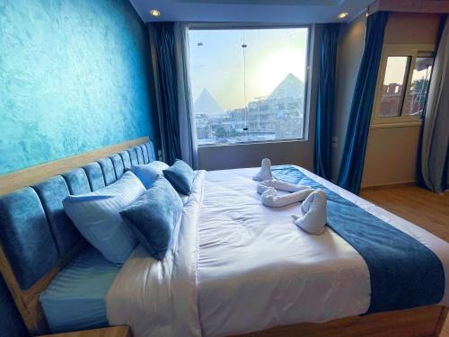 Una cama grande en una habitación con una ventana grande. en Red Pyramids view, en Giza