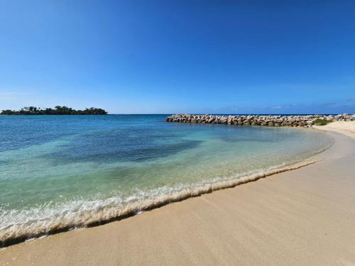 a beach with a group of rocks in the water at Negril beachfront oceanview studios 164 & 145 in Orange Bay