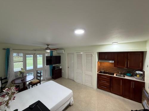 a bedroom with a bed and a table and a kitchen at Negril beachfront oceanview studios 164 & 145 in Orange Bay