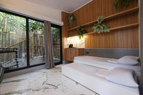 ein Schlafzimmer mit einem Bett und einem großen Fenster in der Unterkunft The Ravine by One Selah in Indang