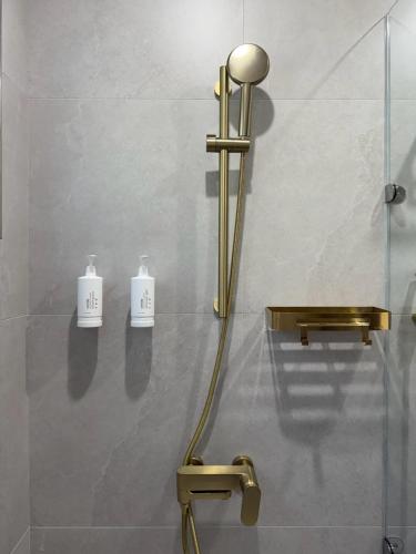 a shower with a gold faucet in a bathroom at Red Brick Villas in Nanzhuang