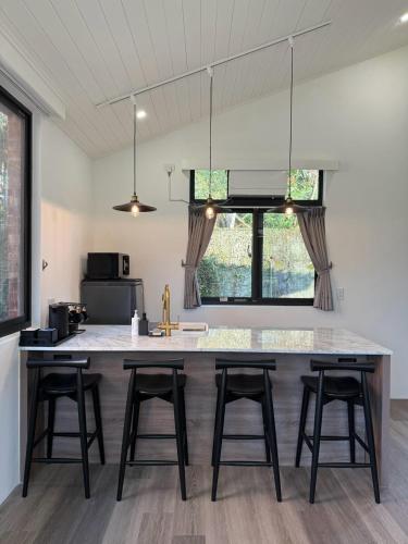 a kitchen with a large kitchen island with four bar stools at Red Brick Villas in Nanzhuang