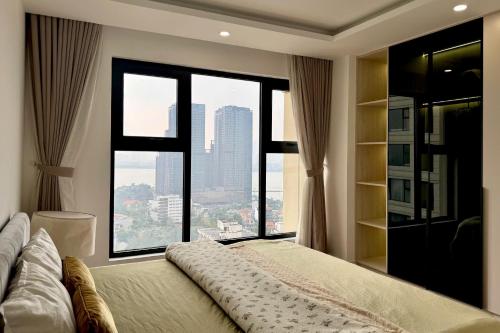 a bedroom with a large bed with a large window at D Le Roi Soleil Premium Suites in Hanoi