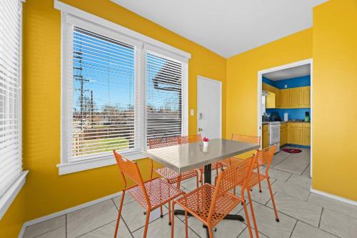 a dining room with yellow walls and a table and chairs at Cozy & Creative Top Unit in Lou's Arts District in Louisville