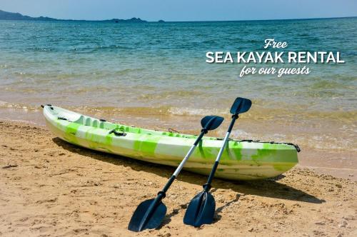 a boat sitting on the beach with two paddles at Sky Ocean - Ishigaki Eco-Resort - Newly Renovated in Ishigaki Island