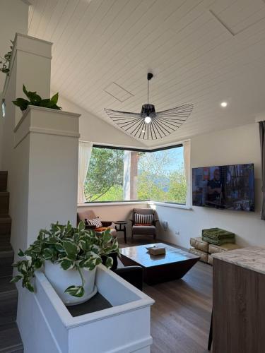 a living room with a potted plant and a ceiling at Red Brick Villas in Nanzhuang