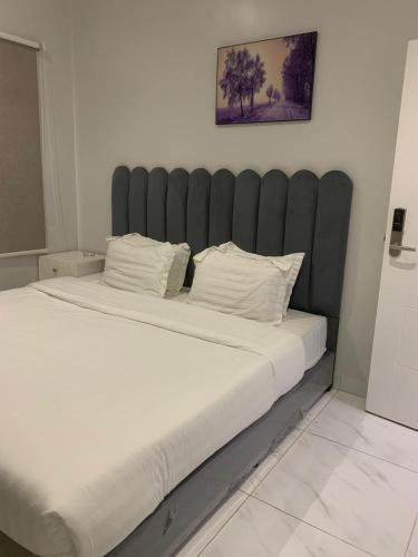 a large bed with a black headboard in a room at skoon rest hotel in Hafr Al Baten