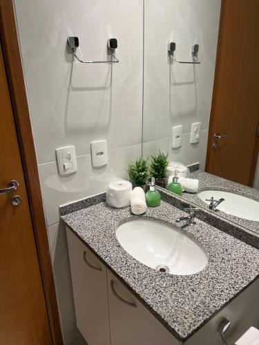 a bathroom with a sink and a mirror at Apartamento de Luxo com Suíte, Academia, Piscina e Mercado in Cuiabá