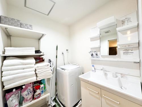a bathroom with a sink and a washing machine at Osaka Nimi family house direct KIX airport in Osaka