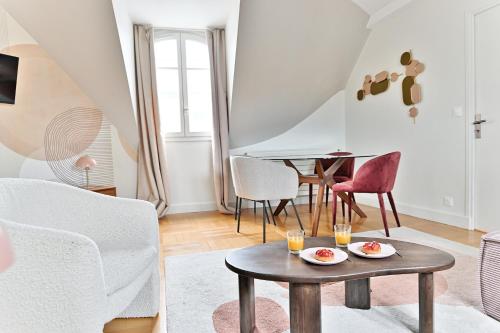 un salon avec une table et des chaises dans l'établissement Lumineux & spacieux - Vue dégagée, Arc de Triomphe, à Paris