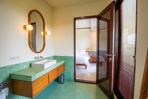 a bathroom with a sink and a mirror at Atelier Home by Great Bali Villas in Krambitan