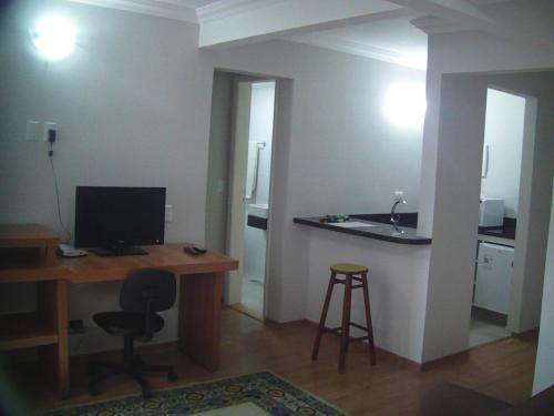 Habitación con escritorio, ordenador y lavabo. en Hotel Ampiezza, en Curitiba