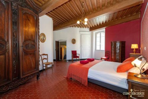 - une chambre avec un grand lit et des oreillers rouges dans l'établissement Le Château d 'Aiguèze, à Aiguèze