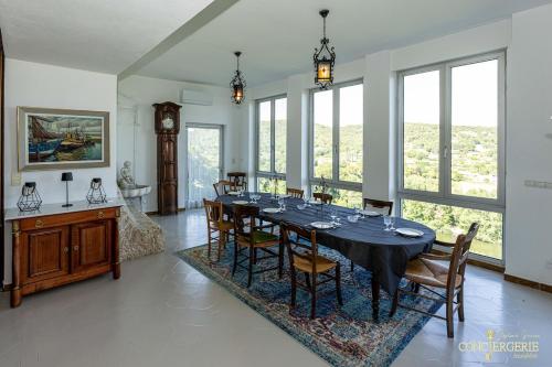 d'une salle à manger avec une table et quelques fenêtres. dans l'établissement Le Château d 'Aiguèze, à Aiguèze
