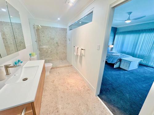 a bathroom with a sink and a toilet and a bedroom at Galley Cove House in Geographe