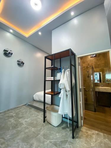 a bathroom with a sink and a shelf with towels at Cabanaz Pool Villa in Ban Zong Katiam