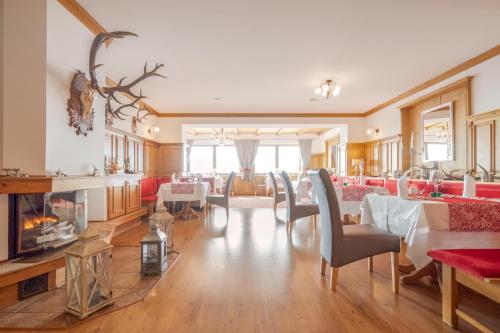 a dining room with tables and chairs and a fireplace at Wellness hotel V Nebi in Kořenov