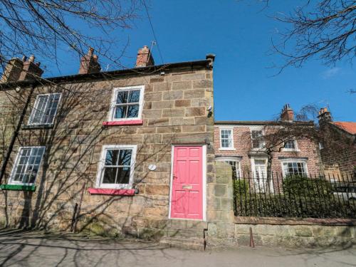 an old brick house with a red door at Red Grouse Cottage in Guisborough
