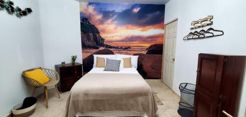 een slaapkamer met een bed met een schilderij aan de muur bij Lofts #9 & #6 Surf EcoVilla Playa El Sunzal in El Sunzal