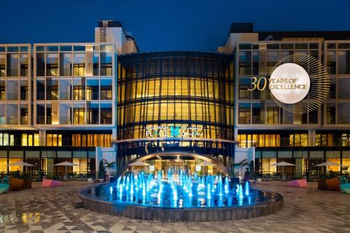 a building with a fountain in front of it at Millennium Place Mirdif in Dubai