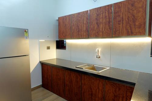 AlleppeySreeragam residency cherthala的带水槽和冰箱的厨房