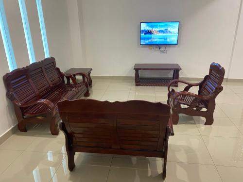 a living room with three chairs and a tv at A Home - Homestay near St Anne Church Bukit Mertajam in Bukit Mertajam