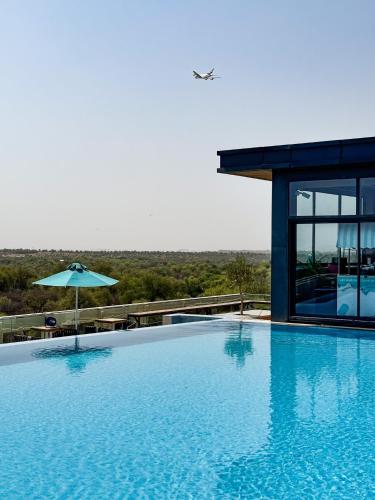 a large swimming pool with an umbrella next to a building at Millennium Place Mirdif in Dubai