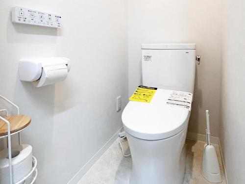 a bathroom with a toilet with a yellow sign on it at D Hotel - Vacation STAY 14103v in Tokyo