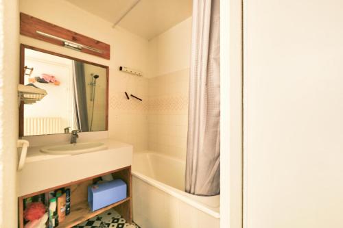 une salle de bain avec un lavabo, un miroir et une baignoire dans l'établissement Résidence Le Montana - maeva Home - Appartement 2 pièces 6 personnes - Confort MAE-5501, à La Mongie