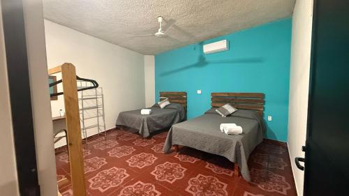 a room with two beds and a bunk bed at Casa Mar Zicatela in Puerto Escondido