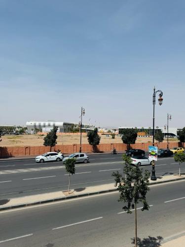 a street with cars driving down a road at Julie Airport Marrakech Apartments in Marrakech