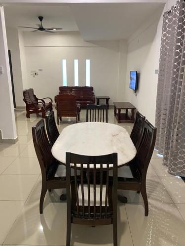 a dining room with chairs and a table and a table and chairsktop at A Home - Homestay near St Anne Church Bukit Mertajam in Bukit Mertajam