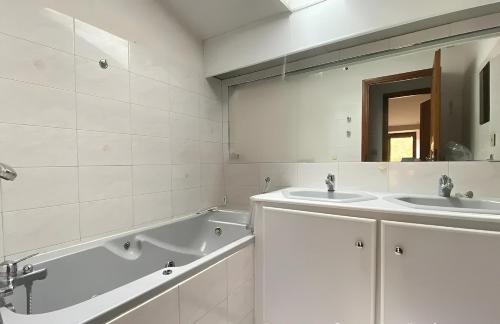 ヴェール・ポン・デュ・ガルにあるLe Mas de mon Pèreの洗面台2つ、浴槽1つ、鏡1つを備えたバスルーム