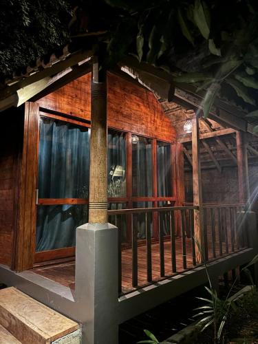 a wooden house with a balcony with a table at B & B Cottages in Unawatuna