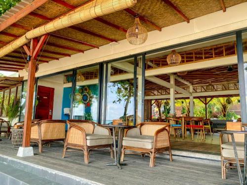 an outdoor patio with chairs and tables and windows at Jimbaran Bay Beach Resort and Spa by Prabhu in Jimbaran