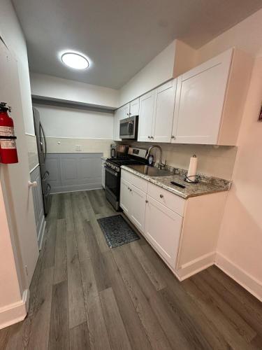 a kitchen with white cabinets and a stove top oven at Family-friendly for travelers in Warwick