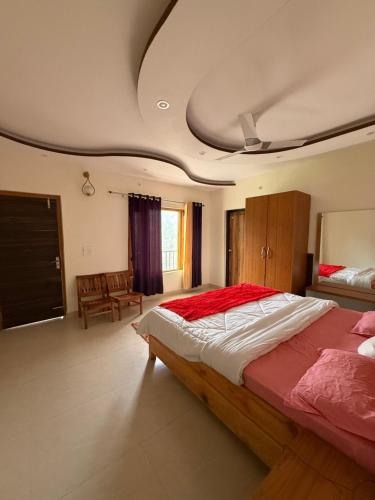 a bedroom with a large bed with a red blanket at Doctor Kush Stay Cafe Music in Rāmgarh