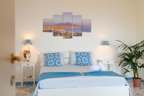 a bedroom with a white bed with blue pillows at Agriturismo Primaluce in Sorrento