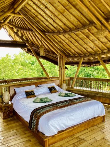 a bed in a room with a wooden roof at Les Terrasses Ceningan in Nusa Lembongan