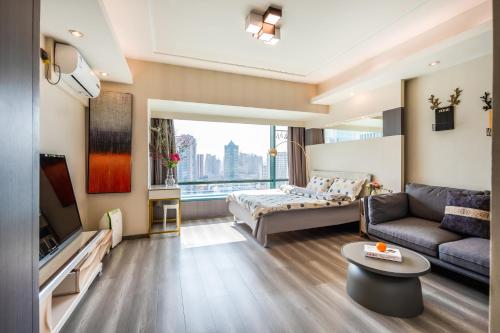 a living room with a couch and a tv at Tech-X Jing'an Hotel in Shanghai