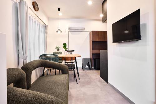 a living room with a couch and a table with chairs at コートハウス三茶 in Tokyo