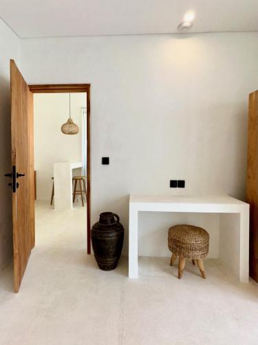 a living room with a white table and a stool at The Ulu Hills in Uluwatu