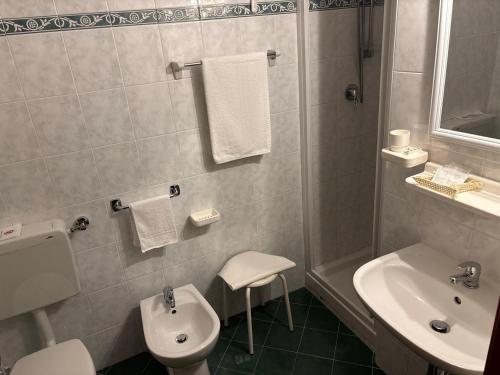 biała łazienka z umywalką i toaletą w obiekcie Albergo Edera w mieście Salsomaggiore Terme
