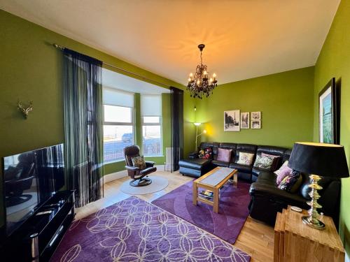 a living room with a couch and a tv at The Beach Front Apartment, Amazing Frontline Sea Views in Tynemouth
