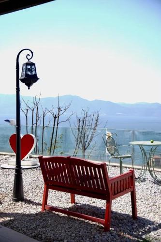 a red bench sitting next to a table and a lamp at Fuxian Lake Three Thousand French Manor Hotel in Xujiadu