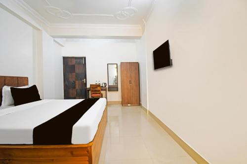 a bedroom with a bed and a tv on a wall at Super Collection O Raja Bazar Bailey Road in Patna