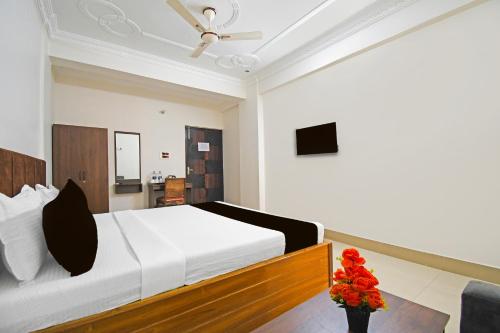 a bedroom with a bed and a vase of flowers at Super Collection O Raja Bazar Bailey Road in Patna