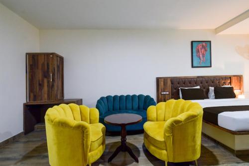 a hotel room with two chairs and a bed at Super Townhouse Vanasthalipuram Formerly Hotel Surabhi in Hyderabad