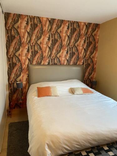 - une chambre dotée d'un lit avec un mur recouvert de poisson dans l'établissement Le Mandarine, T2 proche plage de Morgat, à Crozon