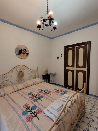 a bedroom with a bed and a chandelier at B&B IL VECCHIO GELSO in Palinuro